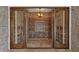 Elegant wine cellar with wooden wine racks, stone walls, and glass doors at 14675 E Paradise Dr, Fountain Hills, AZ 85268
