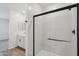 Modern bathroom features a glass shower with black trim, white cabinets and wood-look tile floors at 15769 W Beryl Ave, Waddell, AZ 85355