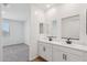 Bright bathroom with double sinks, white cabinets, and a window offering natural light at 15769 W Beryl Ave, Waddell, AZ 85355