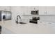 Close up shot of bright kitchen with stainless steel appliances, white cabinets and an island with sink at 15769 W Beryl Ave, Waddell, AZ 85355