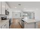 Bright open concept kitchen with stainless steel appliances and white cabinets with views to living area at 15769 W Beryl Ave, Waddell, AZ 85355