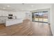 Bright open concept kitchen with white cabinets and wood look floors with views to living area and backyard at 15769 W Beryl Ave, Waddell, AZ 85355