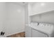 Functional laundry area features a washing machine, dryer, and convenient overhead shelving at 15769 W Beryl Ave, Waddell, AZ 85355