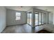 Bright living room featuring wood-style tile flooring and sliding glass doors to the outdoor space at 15769 W Beryl Ave, Waddell, AZ 85355