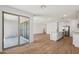 Bright living room with wood-look flooring flowing into a modern kitchen and glass doors to outdoor patio at 15769 W Beryl Ave, Waddell, AZ 85355