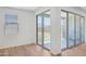 Covered outdoor patio with sliding glass doors and adjacent window showing the backyard and natural light at 15769 W Beryl Ave, Waddell, AZ 85355