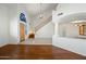Bright, open foyer with wood floors, a decorative window, staircase, and access to other rooms at 16018 N 17Th Way, Phoenix, AZ 85022