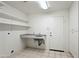 Functional laundry room features ample shelving, counter space, and a utility sink at 16018 N 17Th Way, Phoenix, AZ 85022