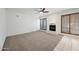 Living room features a cozy fireplace, ceiling fan, and neutral carpet at 16018 N 17Th Way, Phoenix, AZ 85022