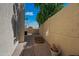 A narrow side yard with gravel, brick pathway, block wall, and a view of neighborhood trees at 16018 N 17Th Way, Phoenix, AZ 85022