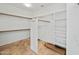 Spacious walk-in closet with built-in shelving, wooden rods and neutral flooring at 16018 N 17Th Way, Phoenix, AZ 85022
