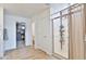 Bright bathroom with a large glass shower, white door, and tile flooring at 16873 W Fetlock Trl, Surprise, AZ 85387
