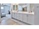 Bathroom featuring double vanity sinks and tile flooring with view to bedroom at 16873 W Fetlock Trl, Surprise, AZ 85387