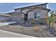 Suburban two-story home with desert landscaping, stone accents, a two-car garage and neutral stucco at 16873 W Fetlock Trl, Surprise, AZ 85387