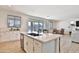 Kitchen island featuring a stainless steel sink, quartz countertop, and backyard views at 16873 W Fetlock Trl, Surprise, AZ 85387