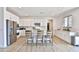 Bright open kitchen featuring white cabinetry, stainless steel appliances, and a central island with barstool seating at 16873 W Fetlock Trl, Surprise, AZ 85387