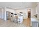 Bright kitchen with stainless steel appliances, wood-look flooring, and a white center island with seating at 16873 W Fetlock Trl, Surprise, AZ 85387