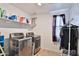 Efficient laundry room with modern washer and dryer, shelving, and natural light at 16873 W Fetlock Trl, Surprise, AZ 85387