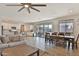 Open-concept living and dining area with wood-look tile floors and neutral decor at 16873 W Fetlock Trl, Surprise, AZ 85387