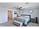 Bright main bedroom with a ceiling fan and a tufted storage bench at the foot of the bed at 16873 W Fetlock Trl, Surprise, AZ 85387
