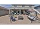 Inviting patio area with outdoor seating, a cozy fire pit, and a relaxing swing for enjoying the backyard at 16873 W Fetlock Trl, Surprise, AZ 85387