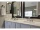 Double sink bathroom vanity with framed mirrors and tile flooring at 18039 W Sunnyslope Ln, Waddell, AZ 85355