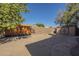 Spacious dirt backyard with a high block fence and wooden gate, plus a storage shed at 18194 N 59Th Ln, Glendale, AZ 85308