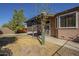 Home's backyard featuring covered patio, desert landscaping, and large windows at 18194 N 59Th Ln, Glendale, AZ 85308