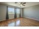 Spacious bedroom with hardwood floors, two windows, and ceiling fan at 18194 N 59Th Ln, Glendale, AZ 85308