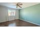 Cozy bedroom with hardwood floors, ceiling fan, neutral wall color, and natural light from the window at 18194 N 59Th Ln, Glendale, AZ 85308
