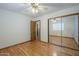 A bedroom featuring wood-look floors, a ceiling fan and closet with mirrored doors at 18194 N 59Th Ln, Glendale, AZ 85308