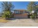 Charming two-story home with a two-car garage, lush trees, and a basketball hoop in the driveway at 18194 N 59Th Ln, Glendale, AZ 85308