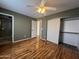 Bright bedroom featuring wood-look floors, ceiling fan, closet, and view to en-suite bathroom at 18221 N 56Th Ln, Glendale, AZ 85308