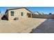 Back exterior of home showing large back yard space with block wall and AC unit at 19685 W Roma Ave, Litchfield Park, AZ 85340