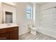 Bathroom with a wood vanity, toilet and shower over tub with tiled floors at 19685 W Roma Ave, Litchfield Park, AZ 85340