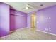 This bedroom has wood-look floors, a ceiling fan, and bright, purple paint at 19685 W Roma Ave, Litchfield Park, AZ 85340