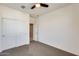 Bedroom with neutral carpet, white sliding-door closet, and a ceiling fan at 19685 W Roma Ave, Litchfield Park, AZ 85340