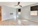 Bright living room with wood-look tile floors, ceiling fan, and large windows with privacy shades at 19685 W Roma Ave, Litchfield Park, AZ 85340