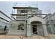 New construction home featuring gray stucco exterior and arched entry, under scaffolding for finishing touches at 1974 W Lariat Ln, Phoenix, AZ 85085