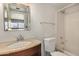 Well-lit bathroom showcases a vanity with a granite countertop and a shower-tub combo with tiled walls at 2048 W Elm St, Phoenix, AZ 85015