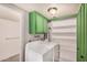 Functional laundry room with a washer, dryer, storage shelves, and green cabinets at 2048 W Elm St, Phoenix, AZ 85015