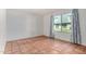 Bright living room with terracotta tile flooring and a large window with patterned curtains at 2048 W Elm St, Phoenix, AZ 85015