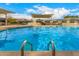 Refreshing community pool featuring clear blue water, sun shades, lounge chairs, and convenient ladder access at 2048 W Elm St, Phoenix, AZ 85015