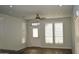 Well-lit living room showcasing large windows, a ceiling fan, and modern flooring at 2206 S Ellsworth Rd # 14 B, Mesa, AZ 85209