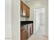 Hallway featuring wooden cabinets with black countertops and carpet flooring leading to a bedroom at 25824 N 54Th Ave, Phoenix, AZ 85083
