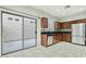 A bright kitchen featuring wooden cabinetry, stainless steel appliances, and sliding glass doors to the patio at 25824 N 54Th Ave, Phoenix, AZ 85083