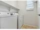 Functional laundry room with washer, dryer, storage shelves, and natural light at 25824 N 54Th Ave, Phoenix, AZ 85083