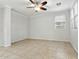 An empty living room with tile flooring, ceiling fan and a large window at 25824 N 54Th Ave, Phoenix, AZ 85083