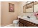 Cozy bathroom featuring a sink, toilet, decorative mirror, and floral wallpaper and wall art at 26242 S Thistle Ln, Sun Lakes, AZ 85248