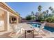 Inviting outdoor patio with comfortable seating, overlooking a stunning pool and tropical landscaping at 26242 S Thistle Ln, Sun Lakes, AZ 85248